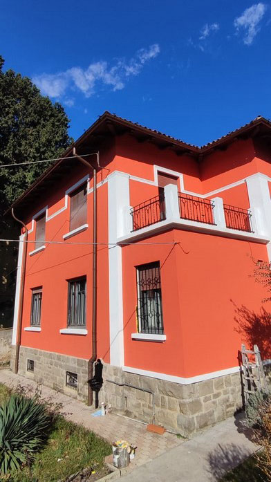 Casa ristrutturata con base in pietra e intonaco